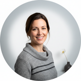Portrait of Rachel Thorne, a woman with a confident smile, wearing a stylish top against a clean white background.